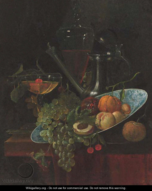 Fruit in a Kraak dish with a pewter ewer and two glasses on a partially draped table - (after) Willem Kalf