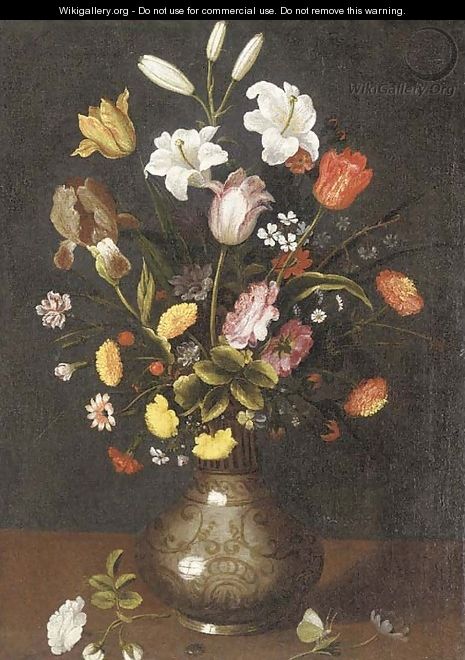 Lilies, tulips, an iris and other flowers in a porcelain vase on a ledge - Spanish School