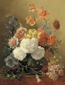 Mixed summer flowers in a glass vase on a ledge - Sara Sartorius