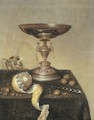 A silver tazza, an upturned roemer, a partly-peeled lemon, a knife and hazelnuts on a draped table - Maerten Boelema De Stomme