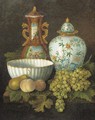 Peaches, grapes, a pear, a porcelain bowl and oriental vases on a plinth - Dutch School