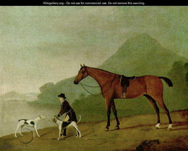 A saddled bay hunter with a groom and hounds, in a landscape - John Best