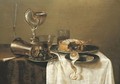 An overturned silver tumbler and a roemer on a pewter plate, a facon-de-Venise wineglass, a nautilus cup, a pie and a partly-peeled lemon - Gerrit Willemsz. Heda