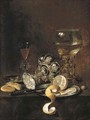 A giant roemer, an upturned goblet, a glass, bread, a knife and a partly-peeled lemon on a platter, on a table - Pieter Claesz.