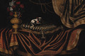 A toy spaniel on an embroidered cushion with a vase of flowers on a draped table - Antonio Gianlisi The Younger