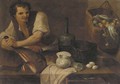 A kitchen interior with a serving boy slicing prosciutto, a basket of vegetables hanging from the wall, bread, a glass, a bottle, and other objects - Carlo Magini