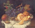 An apple, black grapes, two oranges and cob nuts on oriental plate, with holly in a glass vase, on a wooden table - Eloise Harriet Stannard