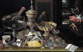 A Still Life Of Coins, Letters, A Silver Tazza, Gilt Vessels, Jewellery And A Silver Beaker Upon A Table, A Miser Haunted By Demons Beyond - (after) Hieronymus II Francken