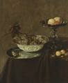 A Still Life With A Wan-Li Porcelain Bowl With Grapes On A Pewter Plate, A Silver Tazza With Peaches, Together With Plums And Nuts, All On A Draped Table - Jan Jansz. Treck