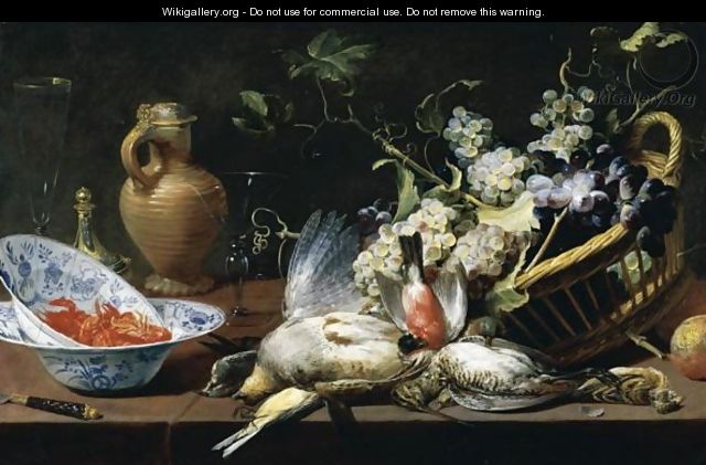 A Still Life Of A Basket Of Grapes, Birds, Including A Partridge, Snipe, Sparrow And Finch, Two Blue-And-White Wan-Li Porcelain Bowls With Langoustines, A Knife, Two Wine Glasses, A Roemer, Stoneware Ewer And A Parcel Gilt Salt Cellar Upon A Stone Ledge - Frans Snyders