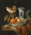 A Still Life With An Orange And Peaches In A Porcelain Wan-Li Bowl, A Nautilus Cup, A Chinese Porcelain Vase - Juriaan Van Streek